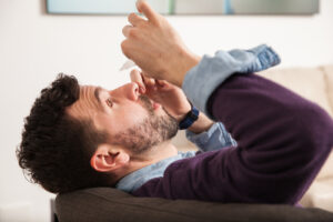man using eye drops