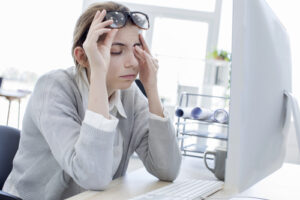 woman at desk with irritated eyes
